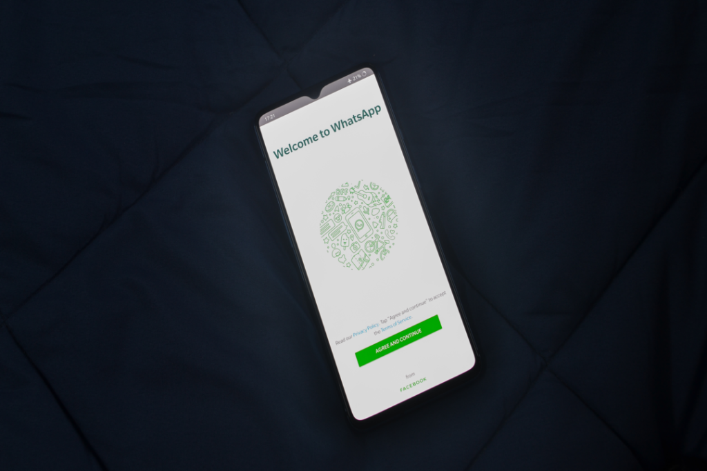 Celular com a tela inicial do WhatsApp escrito "bem vindo" em inglês para demonstrar como vender pelo whatsapp.