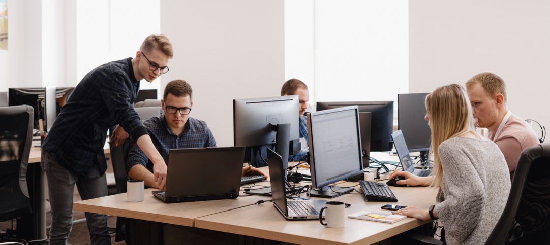 Grupo de trabalhadores utilizando o computador e utilizando ferramentas digitais.