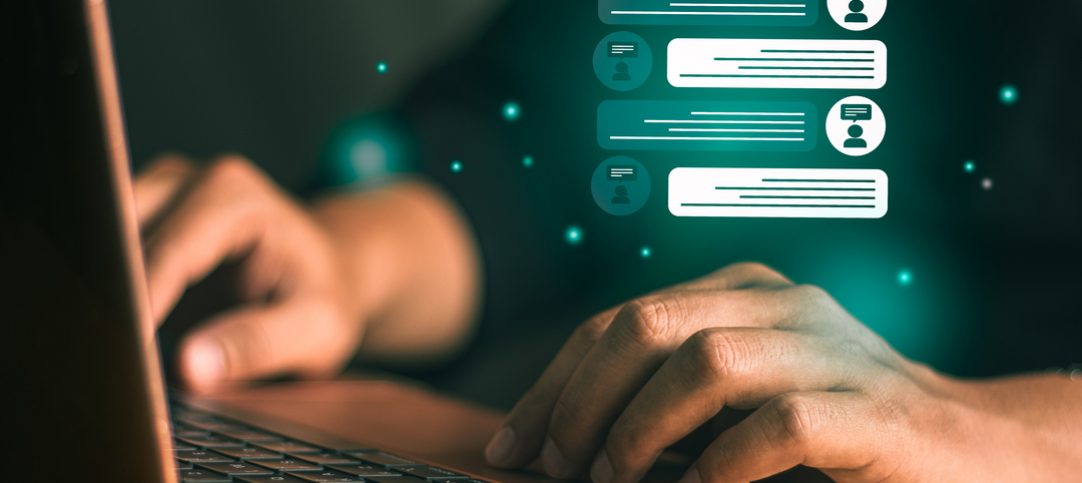 Webchat: imagem mostra homem digitando em seu notebook, com ícones de mensagem flutuando.