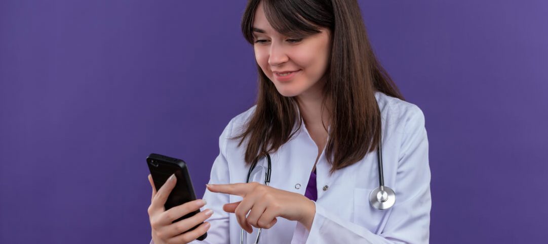 Mulher do setor da saúde mexendo no celular onde atende pelo WhatsApp alguns pacientes.